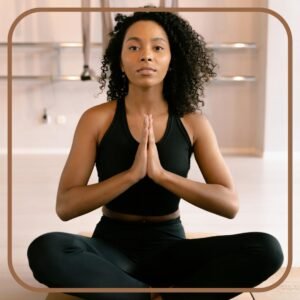 a woman sitting cross legged with hands together in front of her